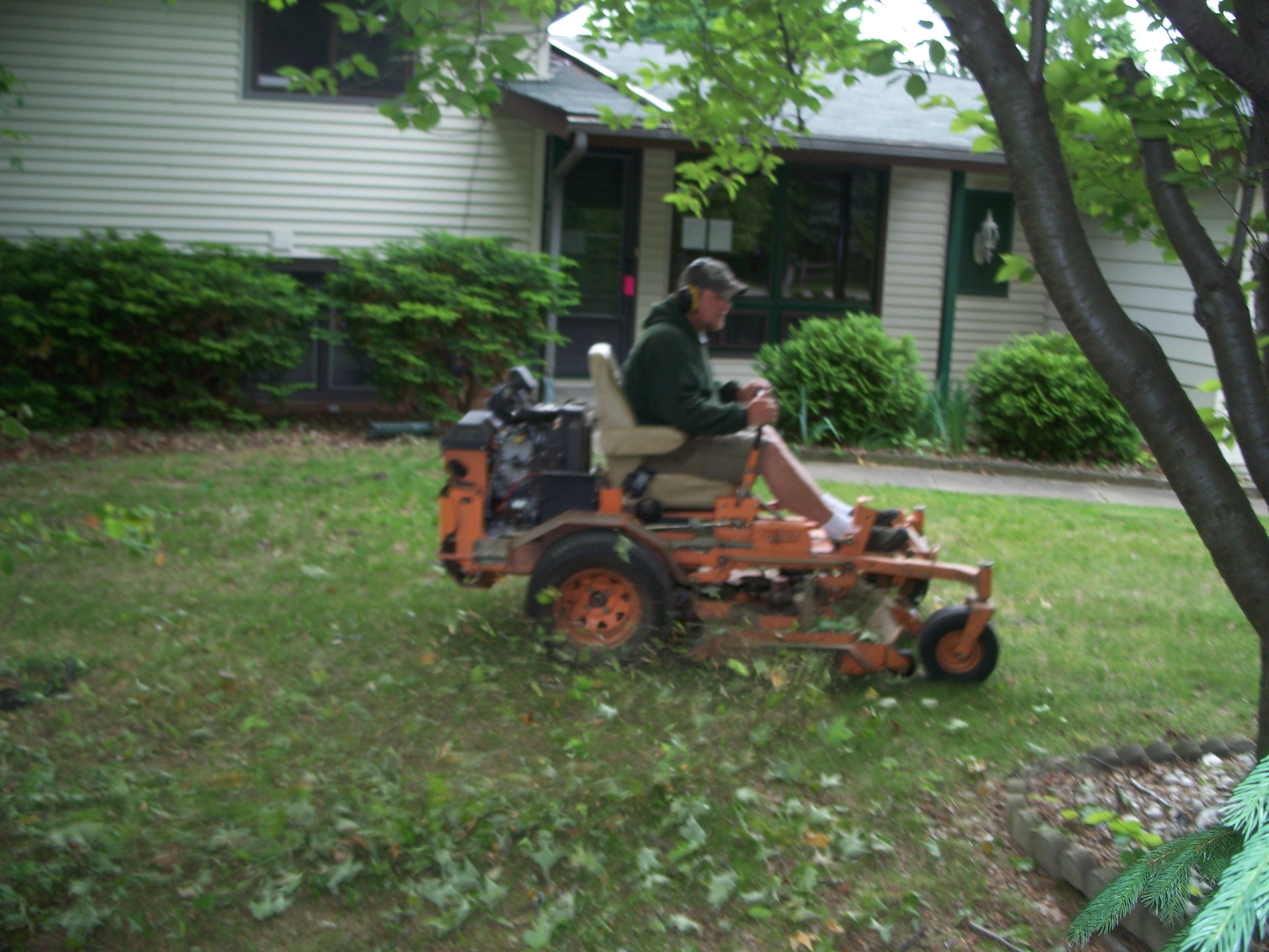 Twin Oaks owner mowing lawns.